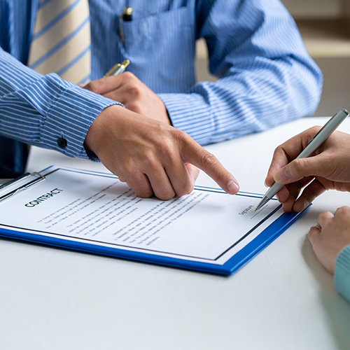 Businesswoman signing a document or application form in a folder, Businessmen hand's pointing where to sign a contract, legal papers or application form.