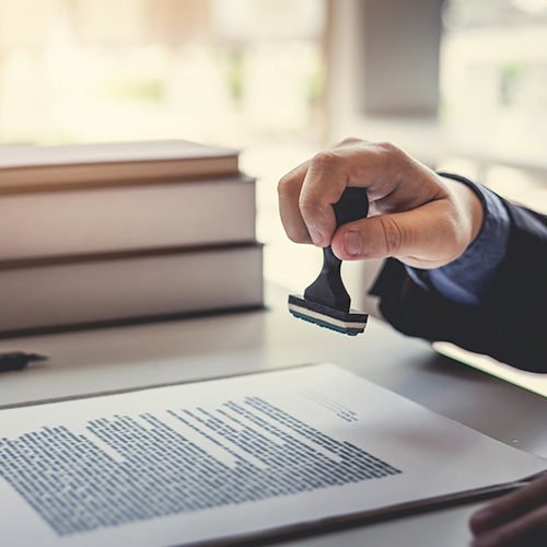 Businessman stamping with approved stamp on document contract.