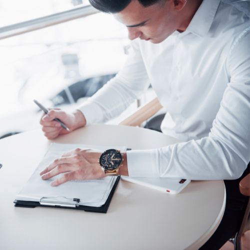 Young man signs documents in the office, successful sales