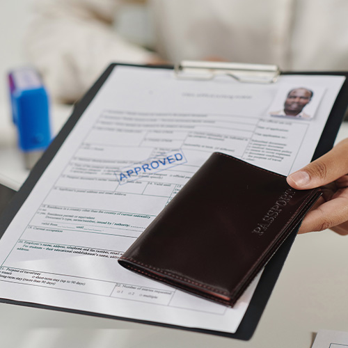 Close-up of specialist giving approved documents and passport to tourist